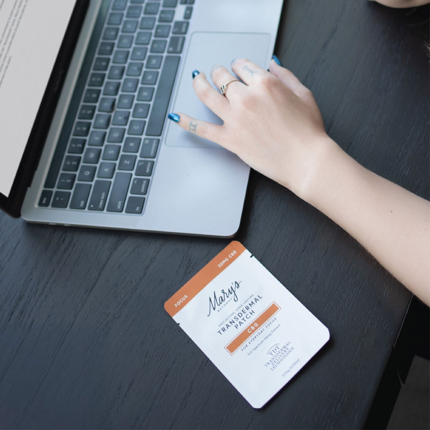 Woman working at computer with Mary's Methods Focus CBG Transdermal patch