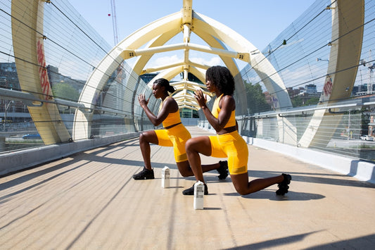 two women exercising on a modern bridge