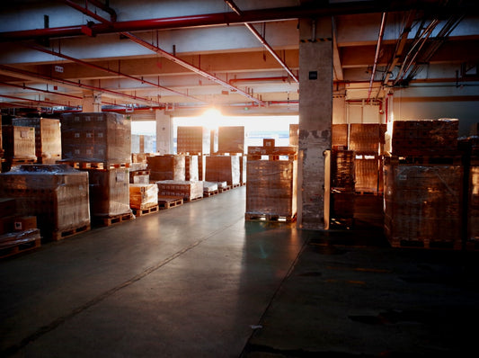 Industrial warehouse interior with stacked pallets and sunlight
