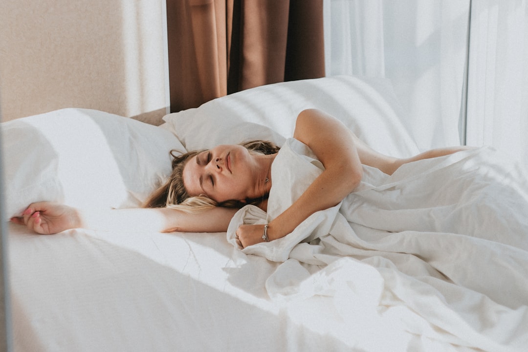 Woman waking up in bed with sunlight