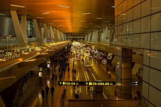 Busy airport terminal with glowing ceiling art