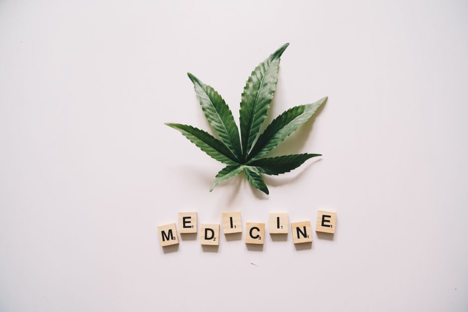 Cannabis leaf above scrabble tiles spelling medicine