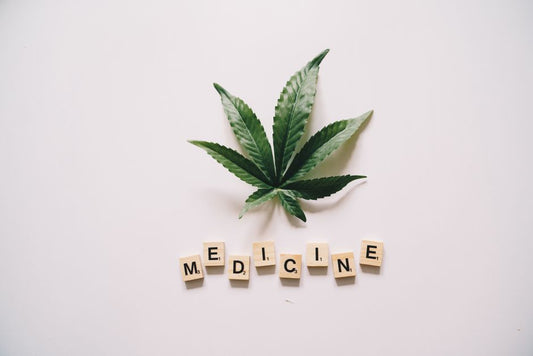 Cannabis leaf above scrabble tiles spelling medicine