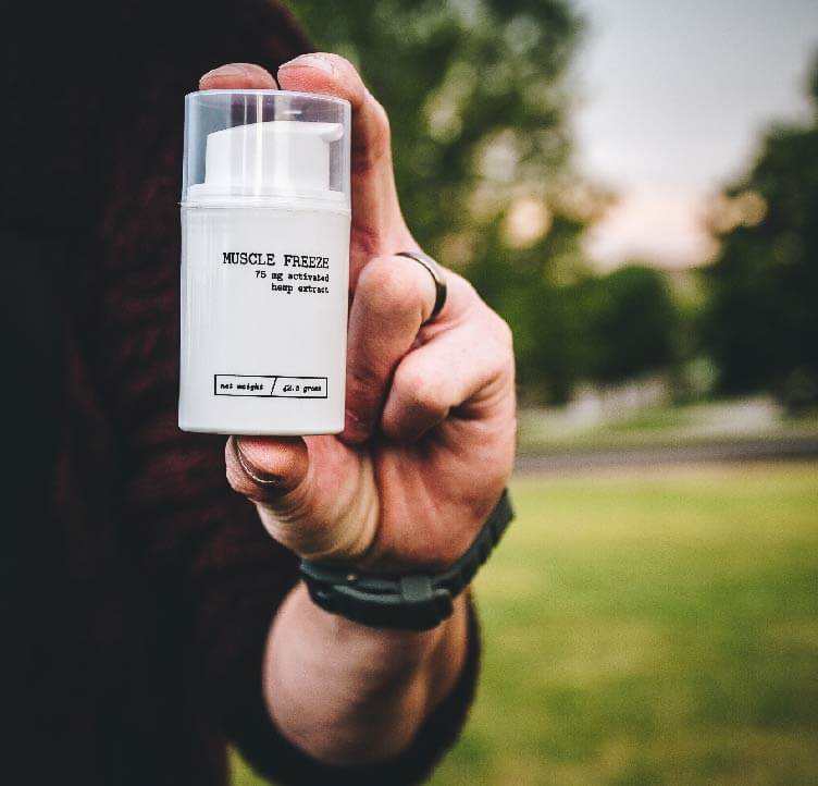 man holding Mary's Nutritionals Muscle Freeze outside
