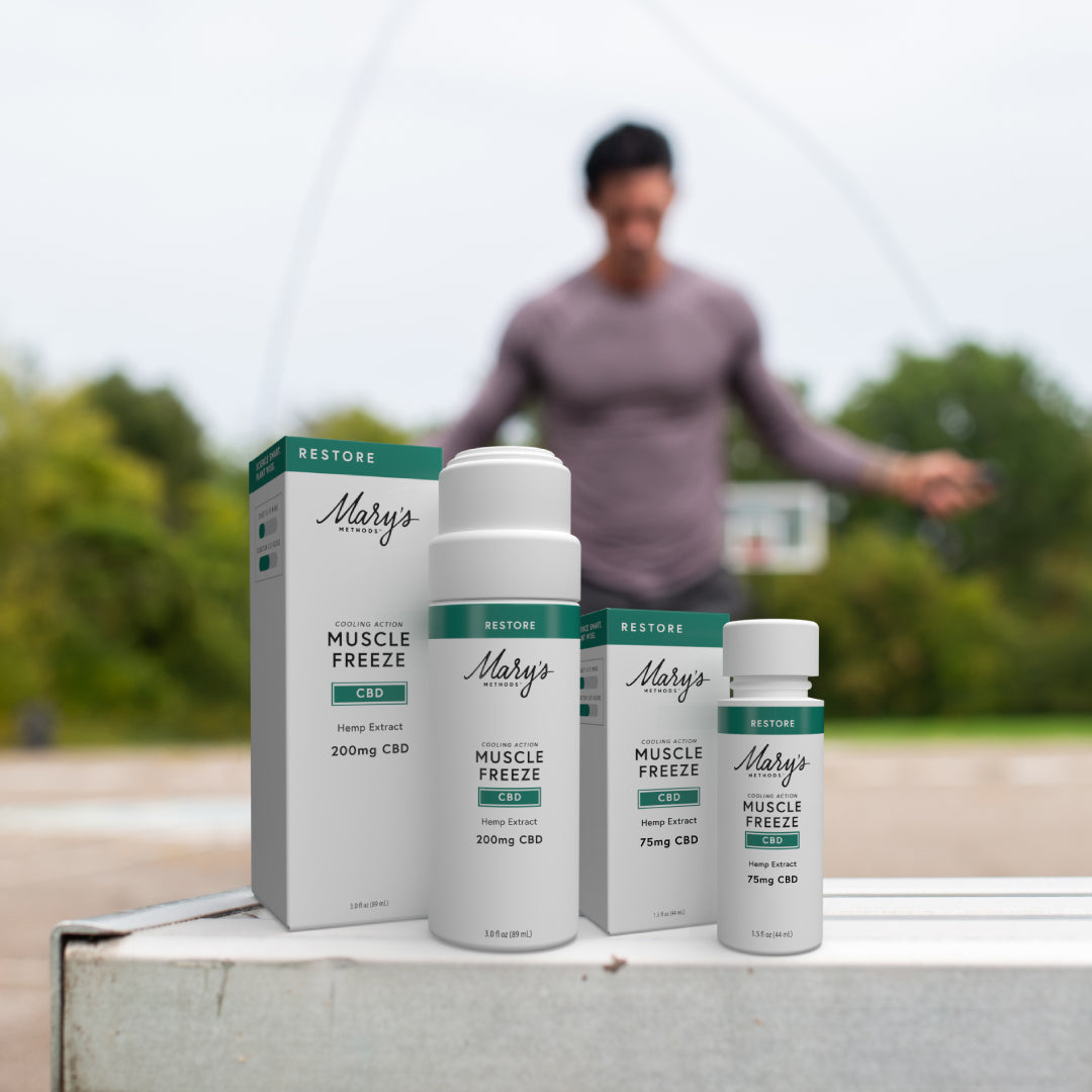 Mary's CBD Muscle Freeze products on a surface with a blurred background of a person exercising outdoors.