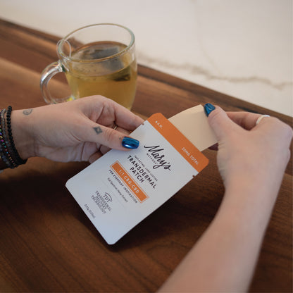 woman drinking tea with Mary's Methods A.M. Transdermal Patch